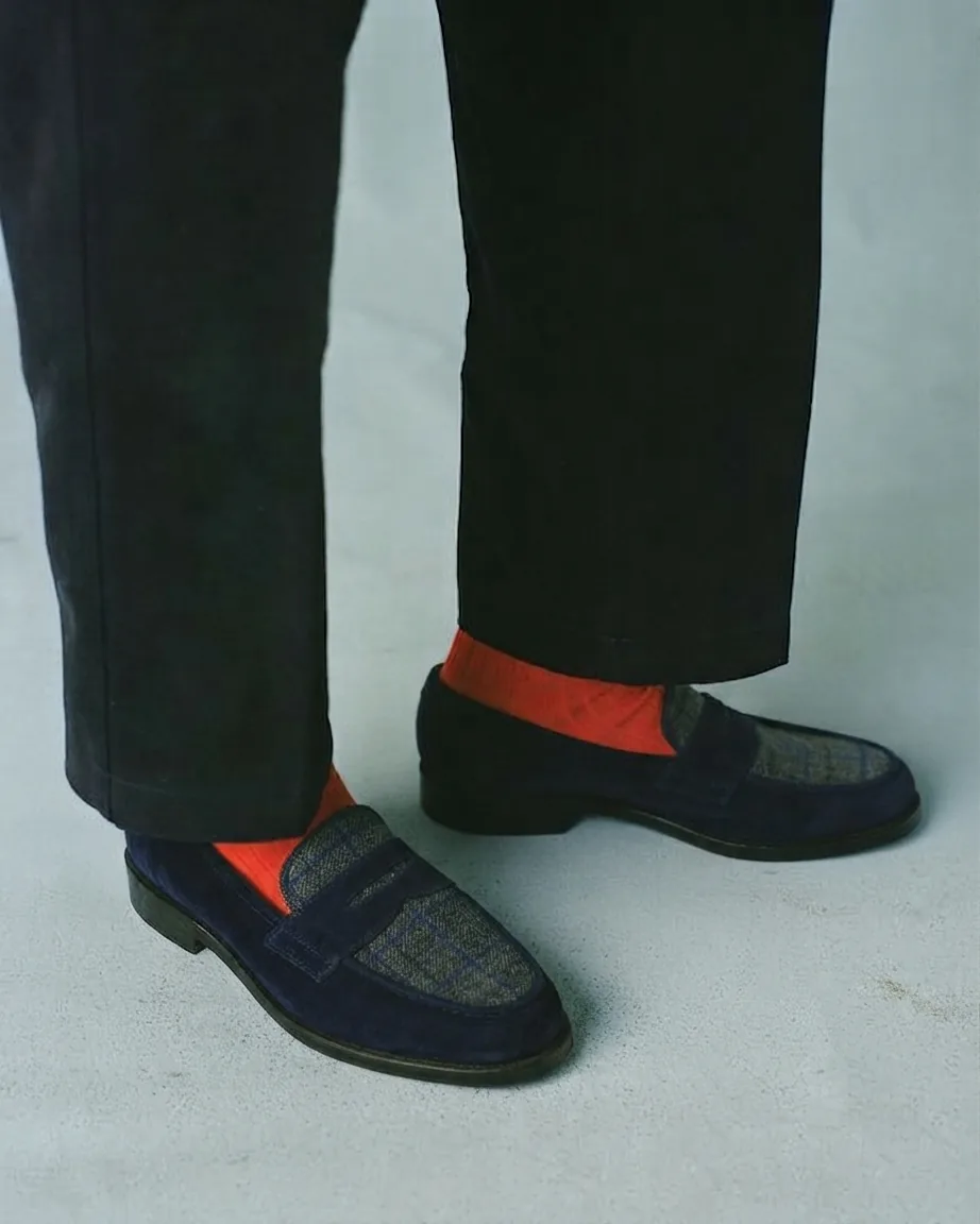 Navy suede loafers with check apron and bright orange socks