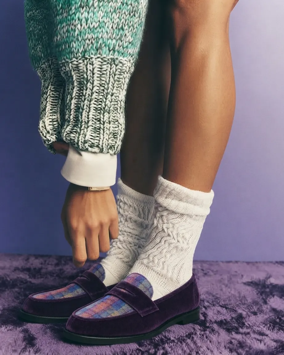 Purple velvet LYL penny loafers with a tartan apron, styled with cable-knit ivory socks
