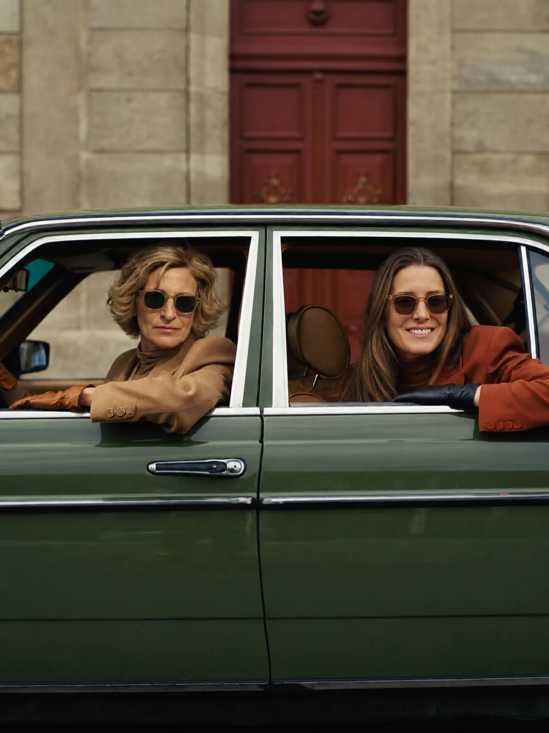 The mother and daughter founders of LARGACHA Y LIEBELT seated in a vintage green car